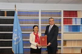Đại sứ Nguyễn Phương Nga trao thư phê chuẩn Hiệp định cấm Vũ khí hạt nhân cho đại diện Ban thư ký Liên hợp quốc. (Ảnh: Nguyễn Hữu Hoàng/TTXVN)