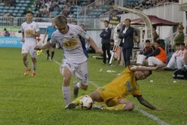 Văn Toàn (số 9, Hoàng Anh Gia Lai) nỗ lực đi bóng qua sự truy cản quyết liệt của cầu thủ đội FLC Thanh Hóa. (Ảnh: Dư Toán/TTXVN)