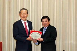 Chủ tịch Ủy ban nhân dân Thành phố Hồ Chí Minh Nguyễn Thành Phong tặng quà ông Chang Soo Huh, Chủ tịch Liên đoàn Công nghiệp Hàn Quốc. (Ảnh: Xuân Khu/TTXVN)