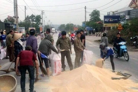 Đông đảo người dân hỗ trợ thu gom cám khô. (Ảnh: Văn Đức/TTXVN)