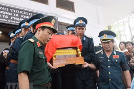 Di quan đưa thi hài của Thượng tá Khuất Mạnh Trí và Đại tá Phạm Giang Nam về mai táng tại quê nhà. (Ảnh: Tá Chuyên/TTXVN)
