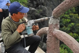 Tháo dỡ công trình vi pham tại khu vực Tràng An cổ. (Ảnh: Minh Đức/TTXVN)