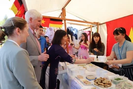 Nghị sỹ Liên bang Đức Johannes Selle (người đứng bên trái) thưởng thức món phở truyền thống của Việt Nam. (Ảnh: Anh Đức/Vietnam+)