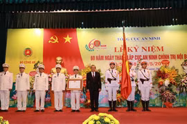 Thừa ủy quyền Chủ tịch nước, Phó Thủ tướng Thường trực Chính phủ Trương Hòa Bình gắn và trao Bằng Huân chương Chiến công hạng Ba lên lá cờ truyền thống của Cục An ninh chính trị nội bộ. (Nguồn: Bộ Công an)