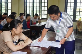 Thí sinh nghe phổ biến quy chế thi và chỉnh sửa thông tin sai sót tại điểm thi Trung học phổ thông Lê Viết Thuật, thành phố Vinh. (Ảnh: Bích Huệ/TTXVN)