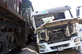 Xe bồn bêtông bị tàu hàng đâm khi cố băng qua đường sắt. (Ảnh: Tá Chuyên/TTXVN)