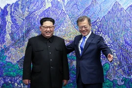 Tổng thống Hàn Quốc Moon Jae-in (phải) và nhà lãnh đạo Triều Tiên Kim Jong-un đứng nói chuyện phía trước bức tranh núi Kumgang trước khi ngồi xuống bàn đàm phán tại Nhà Hòa bình ở làng đình chiến Panmunjom ngày 27/4. (Nguồn: EPA-EFE/TTXVN)