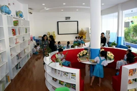 Học sinh đọc sách, vui chơi trong thư viện Trường Tiểu học Phan Văn Trị do Chủ tịch nước Trần Đại Quang và các đại biểu Quốc hội Thành phố Hồ Chí Minh tặng. (Ảnh: Tiến Lực/TTXVN)