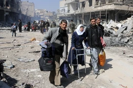 Người dân sơ tán khỏi thị trấn Jisreen, Đông Ghouta ngày 17/3. (Nguồn: AFP/TTXVN)