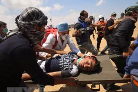 Chuyển người biểu tình Palestine bị thương sau các cuộc đụng độ với binh sỹ Israel tại khu vực biên giới Dải Gaza với Israel ngày 14/5. (Nguồn: AFP/TTXVN)