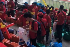 Cổ động viên Việt Nam nhặt rác sau khi kết thúc trận đấu.