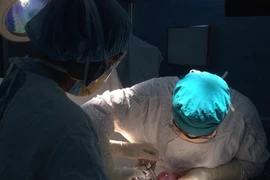 Các bác sỹ đang cắt bỏ u buồng trứng cho bệnh nhân. (Nguồn: TTXVN)