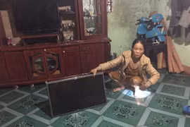 hị Trần Thị Tịnh, thôn 3, xã Nghĩa Hòa, huyện Chư Păh bên cạnh chiếc tivi hỏng do rớt từ trên kệ xuống do rung chấn mạnh khi tuyến đường đang thi công ngang qua nhà. (Ảnh: Hồng Điệp/TTXVN)
