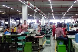 Công nhân Công ty trách nhiệm hữu hạn PouYuen Việt Nam (quận Bình Tân, Thành phố Hồ Chí Minh) trong giờ sản xuất tại khu B. (Ảnh: Thanh Vũ/TTXVN)