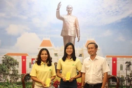 Ông Huỳnh Thanh Nhân, Giám đốc Sở Văn hóa và Thể thao Thành phố Hồ Chí Minh trao tặng quà cho vận động viên Tú Chinh và huấn luyện viên trước khi lên đường tập huấn tại Mỹ. (Ảnh: Xuân Dự/TTXVN)