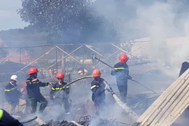 Lực lượng chữa cháy tiếp cận hiện trường vụ hỏa hoạn tại thị trấn Lạc Dương (huyện Lạc Dương) vào trưa 1/1. (Ảnh: Nguyễn Dũng/TTXVN)