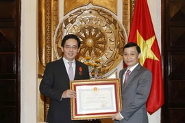 Ủy viên Ban Chấp hành Trung ương Đảng, Thứ trưởng Bộ Ngoại giao Lê Hoài Trung trao Huân chương Hữu nghị cho ông Hồng Tiểu Dũng. (Ảnh: Văn Điệp/TTXVN)