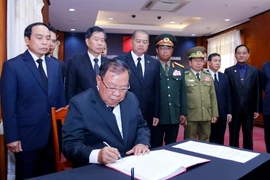 Tổng Bí thư, Chủ tịch nước Lào Bounnhang Vorachith ghi sổ tang tại lễ viếng Chủ tịch nước Trần Đại Quang. (Ảnh: Phạm Kiên/Vietnam+)