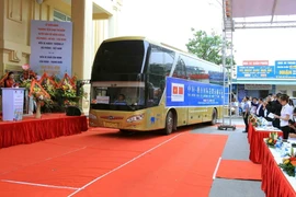 Các đại biểu chứng kiến xe ôtô khách của Việt Nam và Trung Quốc lăn bánh xuất phát đi Côn Minh, Trung Quốc. (Ảnh: An Đăng/TTXVN)