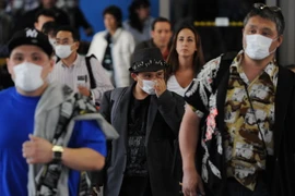 Khách du lịch sử dụng khẩu trang phòng dịch cúm lây lan tại sân bay quốc tế Los Angeles, Mỹ. (Nguồn: AFP/TTXVN)