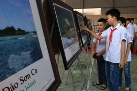 Các em học sinh tham quan triển lãm. (Ảnh: Vũ Hoàng Giang/TTXVN)