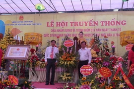 Ban tổ chức nhận hoa chúc mừng lễ khai hội chùa Nhẫm Dương. (Ảnh: Hiền Anh/TTXVN)