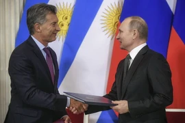 Tổng thống Nga Vladimir Putin (phải) và người đồng cấp Argentina Mauricio Macri trao đổi văn kiện sau lễ ký thỏa thuận tại Moskva, Nga ngày 23/1. (Nguồn: AFP/TTXVN)