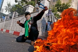 Người biểu tình Palestine ném đá vào lực lượng an ninh Israel, phản đối quyết định của Tổng thống Mỹ công nhận Jerusalem là thủ đô của Israel tại thành phố Hebron, Khu Bờ Tây ngày 8/12/2017. (Nguồn: AFP/ TTXVN)