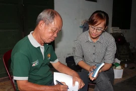 Cựu chiến binh, nhà báo Trịnh Phi Long (trái) trao đổi kinh nghiệm nghề báo với phóng viên TTXVN. (Ảnh: Xuân Khu/TTXVN)