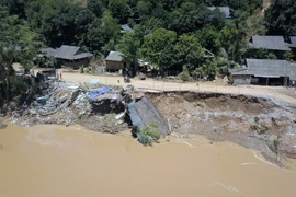 Nhà của người dân bị sụt xuống sông khi một đoạn đường từ Thủy điện Trung Sơn qua bản Bó bị sạt lở. Đây là con đường nối liền hai xã Thành Sơn, Trung Sơn (huyện Quan Hóa) và xã Mường Lý (huyện Mường Lát). (Ảnh: Trọng Đạt/TTXVN)