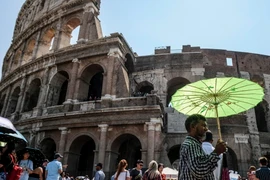 Người dân che ô tránh nắng nóng tại Rome, Italy ngày 2/8. (Ảnh: AFP/TTXVN)