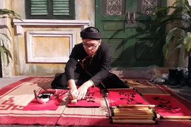 Ông đồ viết thư pháp tại chương trình Tết Việt. (Ảnh: Đinh Thuận/TTXVN)