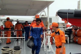 Đón và tiếp nhận 2 ngư dân bị nạn trở về. (Ảnh: Đoàn Mạnh Dương/TTXVN)