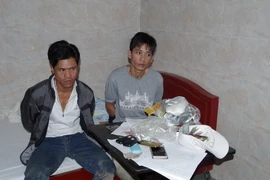 Các đối tượng bị bắt cùng tang vật của vụ án. (Ảnh: Cao Nguyên/TTXVN)
