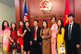 Đại sứ Lê Quý Quỳnh và phu nhân chụp ảnh kỷ niệm cùng một số bà con cộng đồng. (Ảnh: Lê Hòa/Vietnam+)