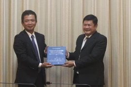Phó Chủ tịch Ủy ban Nhân dân Thành phố Hồ Chí Minh Huỳnh Cách Mạng tặng quà lưu niệm cho ông Kadowaki Keiichi. (Ảnh: Xuân Anh/TTXVN)