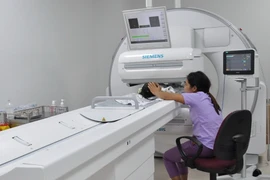 Bệnh nhi đầu tiên chuẩn bị được xạ hình. (Ảnh: Đinh Hằng/TTXVN)