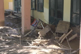 Bàn ghế, đồ dùng ngổn ngang trong bùn đất. (Ảnh: Khiếu Tư/TTXVN)