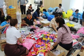 Đóng gói hàng hóa để vận chuyển tới vùng bị sự cố vỡ đập thủy điện. (Ảnh: Phạm Kiên/TTXVN)