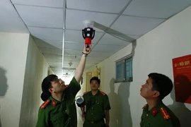 Cảnh sát phòng cháy, chữa cháy kiểm tra hệ thống báo cháy tại chung cư HH Linh Đàm. (Ảnh: TTXVN)