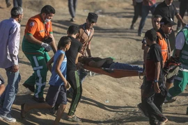  Chuyển người bị thương trong xung đột giữa binh sỹ Israel với người biểu tình Palestine tại khu vực biên giới giữa Dải Gaza với Israel ngày 27/7. (Nguồn: THX/TTXVN)