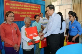 Chủ tịch Ủy ban Trung ương Mặt trận Tổ quốc Việt Nam Trần Thanh Mẫn tặng quà cho hộ nghèo ở xã Long Đức. (Ảnh: Thanh Hòa/TTXVN)