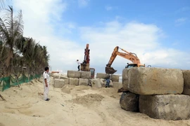 Cán bộ Đội Quy tắc đô thị quận Ngũ Hành Sơn kiểm tra việc tháo dỡ công trình vi phạm. (Ảnh: Nguyễn Sơn/TTXVN)