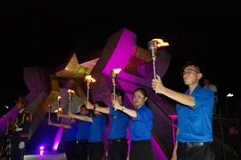 Các đoàn viên, thanh niên thực hiện nghi lễ rước đuốc ở Nghĩa trang Liệt sỹ Quốc gia Đường 9. (Ảnh: Thanh Thủy/TTXVN)