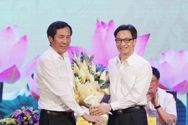 Phó Thủ tướng Vũ Đức Đam (bên phải) tặng hoa Chủ tịch Hội Nhà báo Việt Nam Thuận Hữu, chúc mừng những người làm báo trên cả nước. (Ảnh: Lâm Khánh/TTXVN)
