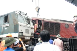 Máy cẩu chuyên dụng tách 2 đầu máy tàu dính vào nhau. (Ảnh: Đỗ Trưởng/TTXVN)