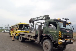 Đưa xe bị tai nạn về nơi xử lý. (Ảnh: Nguyễn Sơn/TTXVN)