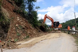 Các lực lượng chức năng huy động máy xúc để giải tỏa điểm sạt lở đất đá trên Quốc lộ 7 đoạn qua địa bàn xã Hữu Kiệm, huyện Kỳ Sơn, tỉnh Nghệ An. (Ảnh: Tá Chuyên/TTXVN)