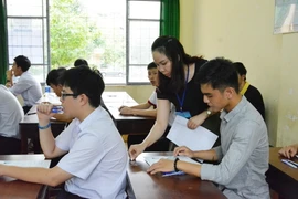 Cán bộ coi thi ghi số báo danh thi môn Ngữ văn. (Nguồn: TTXVN)