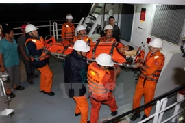 Chăm sóc y tế cho nạn nhân gặp nạn khi vừa được đưa về bờ. (Ảnh: TTXVN phát)